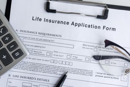 Life insurance document with calculator and glasses